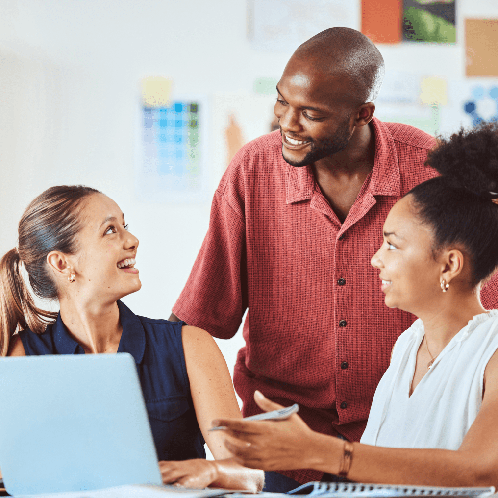 Male professional talking with female clients in a modern office meeting